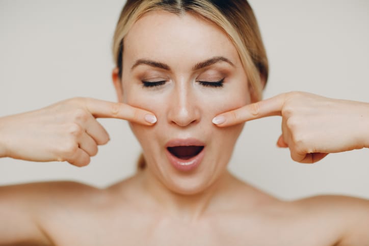 Young adult doing facial gymnastics self massage and rejuvenating exercises face building for skin and muscles lifting