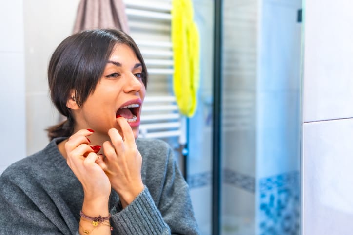 Woman placing transparent brackets in the toilet
